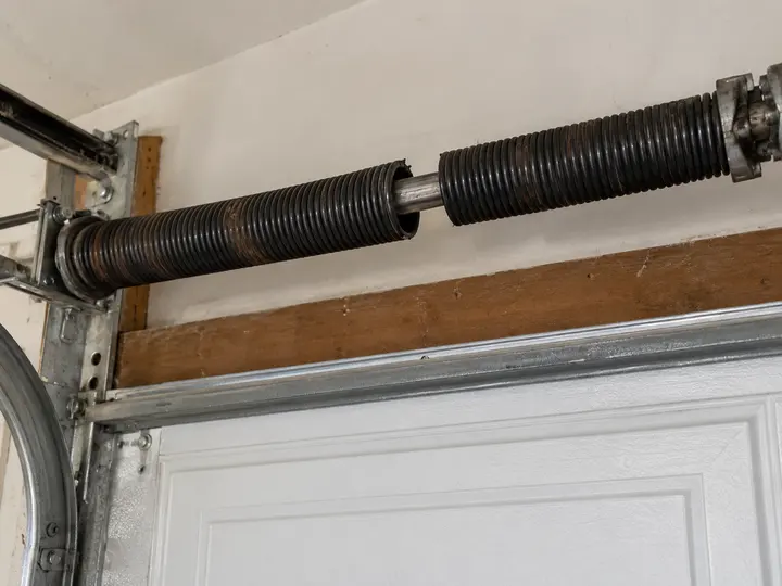 Broken torsion spring with a gap between the coils above a garage door